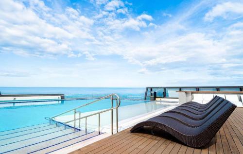 łóżko na balkonie z widokiem na ocean w obiekcie The BlueMark Hotel Sokcho w mieście Sokcho