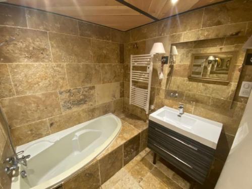 une salle de bain avec une baignoire et un lavabo dans l'établissement Grande maison avec piscine chauffée au Clos Caché!, à Escamps