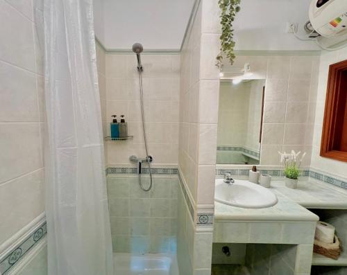 uma casa de banho com um chuveiro e um lavatório. em Beachfront Apartment in Cala Morell em Cala Morell