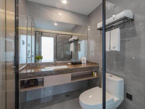uma casa de banho com um WC, um lavatório e um espelho. em Gya Hotel Kunming Zijin Center Xiaodongcun Metro Station em Kunming
