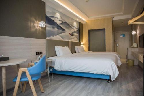 a hotel room with a large bed and a table at Hanting Hotel Shenzhen Longgang Nanlian Metro Station in Longgang