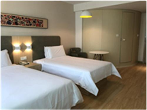 Een bed of bedden in een kamer bij Hanting Hotel Zhuhai Hengqin International Convention and Exhibition Center