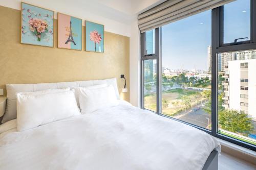 a bedroom with a white bed and a large window at Cardinal Court Phu My Hung near SECC & Crescent in Ho Chi Minh City