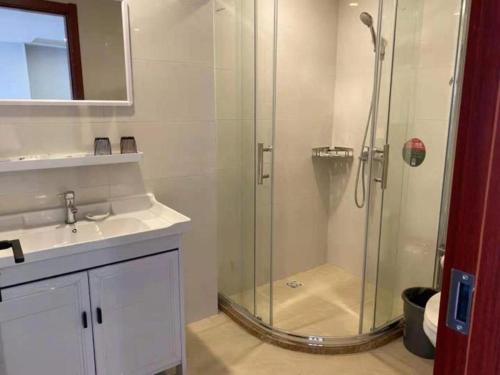 GreenTree Alliance Hotel Jiangsu Suzhou Xiangcheng Distrcit Dongqiao في Sangshubang: حمام مع دش زجاجي ومغسلة