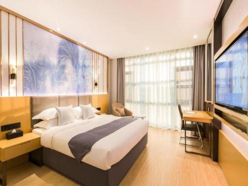 ein Hotelzimmer mit einem großen Bett und einem TV in der Unterkunft GreenTree Eastern Hotel Tianjin Dongli Development Zone Xinli Metro Station in Luotuofangzi