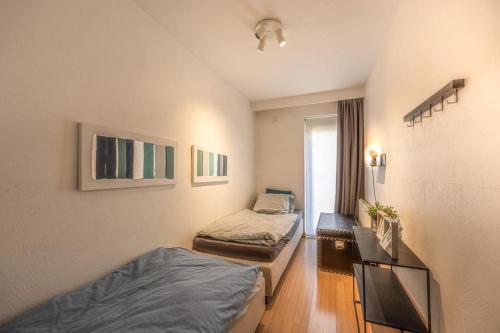 ein kleines Zimmer mit 2 Betten und einem Fenster in der Unterkunft Appartement Knokke-Heist in Knokke-Heist