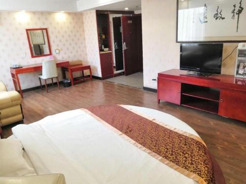 - un salon avec un lit et une télévision dans l'établissement Super 8 Hotel Jinan West Gate of Long Distance Bus Station, à Beiyuan