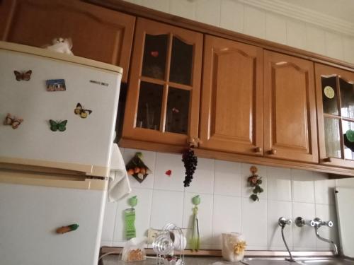 a kitchen with a white refrigerator and wooden cabinets at Квартира в престижном районе Баку in Baku