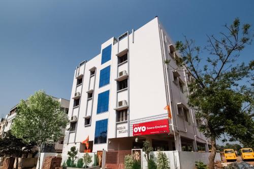 a white building with a sign on the side of it at OYO Seera Enclave in Rājahmundry