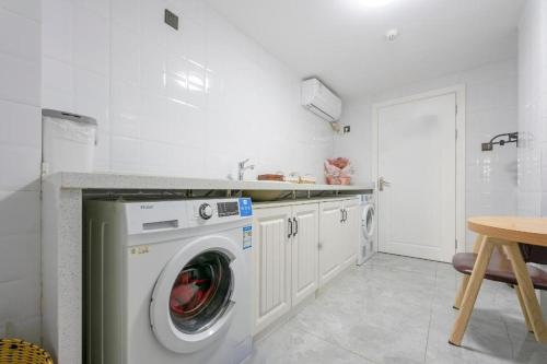 a kitchen with a washing machine and a sink at Hanting Hotel Shangrao Wanda in Shangrao