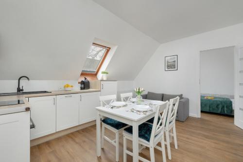 eine Küche und ein Esszimmer mit einem weißen Tisch und Stühlen in der Unterkunft Unique Apartments in Szczecin by Rent like home in Stettin