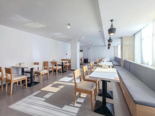 uma sala de jantar com mesas e cadeiras num restaurante em Hanting Hotel Wuhan Xinhua Road Xiehe Hospital em Wuhan