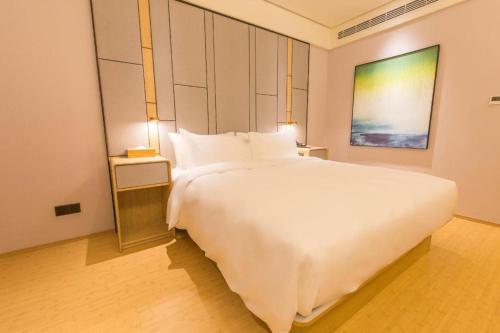 Un pat sau paturi într-o cameră la Ji Hotel Suzhou High-tech Zone Xingyue Bay