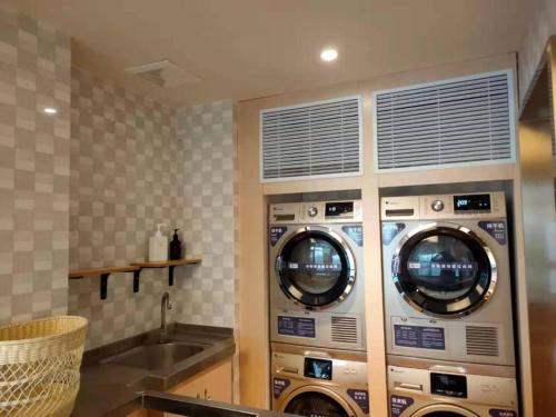 cztery pralki w kuchni ze zlewem w obiekcie Ji Hotel Wuxi Shuofang Airport w mieście Daqiangmen