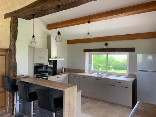 une grande cuisine avec un comptoir et une fenêtre dans l'établissement Maison en pierre situé au milieu des champs de blé, à Pern