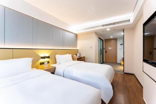 מיטה או מיטות בחדר ב-Nihao Hotel Hangzhou Chaowang Road Shentangqiao Metro Station