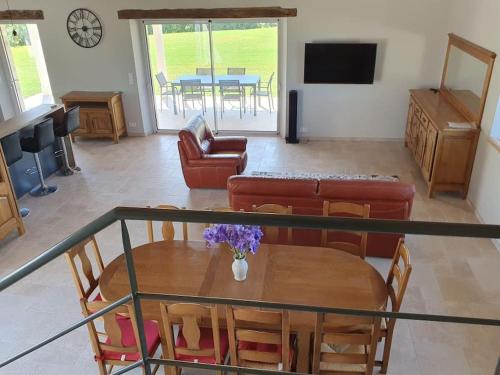 un salon avec une table et un canapé dans l'établissement Maison en pierre situé au milieu des champs de blé, à Pern