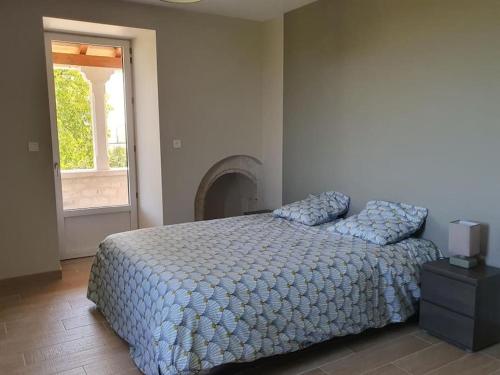 - une chambre avec un lit, une cheminée et une fenêtre dans l'établissement Maison en pierre situé au milieu des champs de blé, à Pern