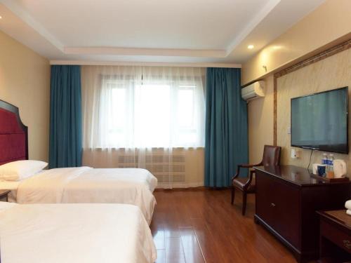 ein Hotelzimmer mit 2 Betten und einem Flachbild-TV in der Unterkunft Starway Hotel Ha'Erbin Convention And Exhibition Center in Harbin