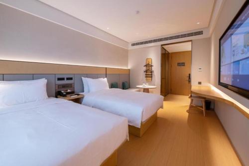 Una cama o camas en una habitación de Ji Hotel Shanghai Yangpu Gym