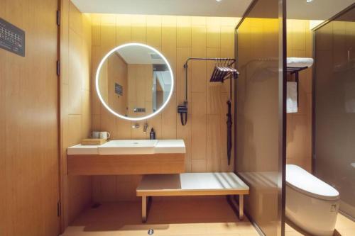 a bathroom with a sink and a mirror and a toilet at Ji Hotel Shanghai Yangpu Gym in Shanghai
