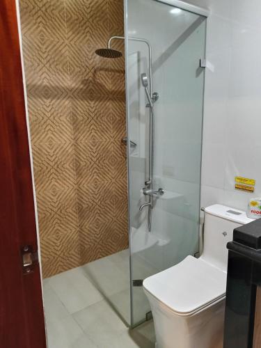 a shower stall in a bathroom with a toilet at Norlu Cedec Midpoint Hotel in Rosario
