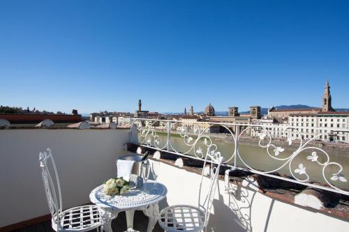 a balcony with a table and chairs and a view of the city at Serristori Palace Residence in Florence