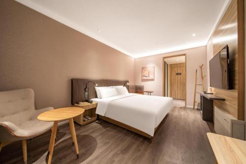 سرير أو أسرّة في غرفة في Hanting Hotel Jinan International Expro Center
