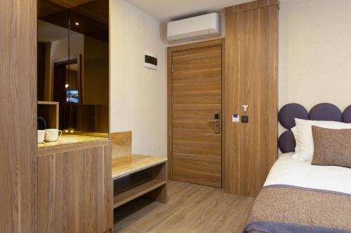 a bedroom with a bed and a wooden door at Ema Houses in Antalya