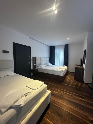 a hotel room with two beds and wooden floors at 4 Stinët in Valbonë