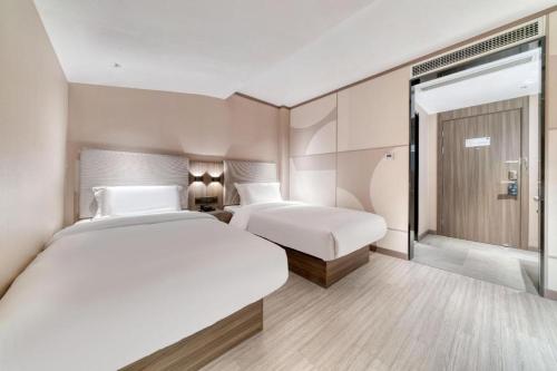 سرير أو أسرّة في غرفة في Hanting Hotel Hangzhou East Railway Station Airport Road