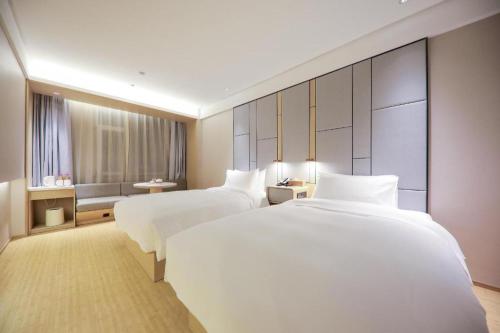 A bed or beds in a room at Ji Hotel Qingdao Dengzhou Road Beer Street