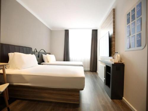 Ein Bett oder Betten in einem Zimmer der Unterkunft Hanting Premium Hotel Changchun Railway Station