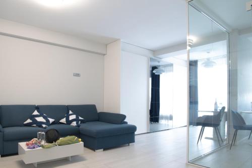 a living room with a blue couch and a table at Oltenia Studio Happy Residence Craiova in Craiova