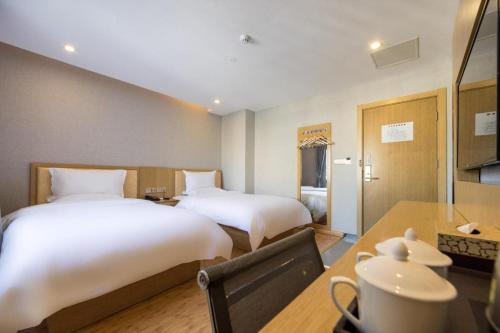 Un pat sau paturi într-o cameră la Hanting Hotel Shanghai Waitan Jiujiang Road