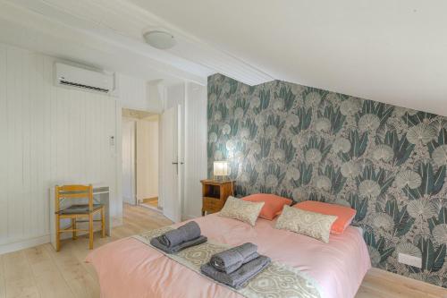 a bedroom with a pink bed with a floral wallpaper at Gîte La Terrasse, 4 chambres, 10 pers, Centre Ville in Lagnieu