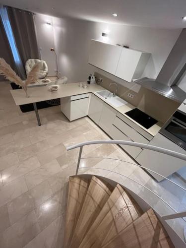 une chambre avec un escalier et une cuisine avec un évier dans l'établissement Joli Appartement, à Épinal