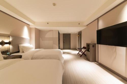 سرير أو أسرّة في غرفة في Hanting Hotel Xi'an Park South Road