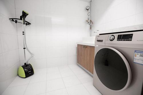 a washing machine in a bathroom with a vacuum at Starway Hotel Zhengzhou Jingguang Road Metro Station in Zhengzhou