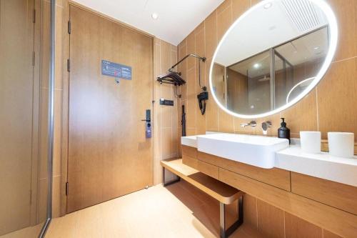 W łazience znajduje się biała umywalka i lustro. w obiekcie Ji Hotel Shanghai Daning International w Szanghaju