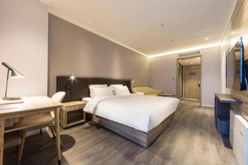 Tempat tidur dalam kamar di Hanting Premium Hotel Zhengzhou Huayuan Road International Trade Center