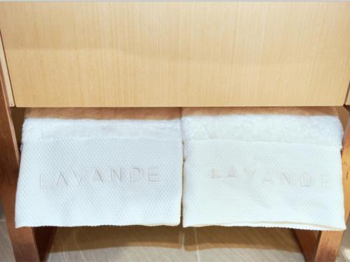 two white towels in a wooden drawer with the words laundry at Lavande Hotel Changchun Gaoxin Jilin University in Changchun