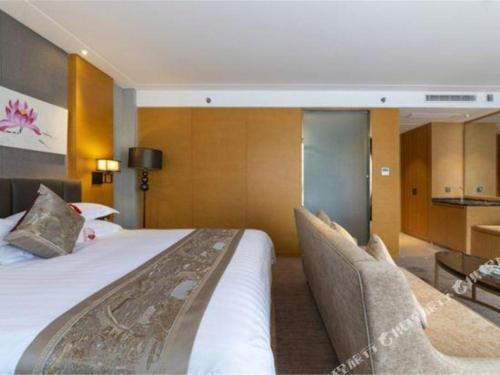 Habitación de hotel con 1 cama grande y 2 sillas en Borrman Hotel Jinan Yijia Exhibition Center Laotun Metro Station en Jinan