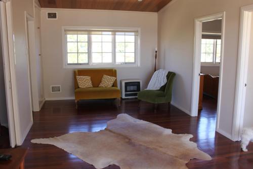 una sala de estar con 2 sillas y una alfombra en el suelo en Busselton Beachside, en Busselton
