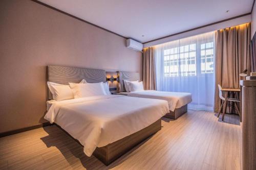 Un ou plusieurs lits dans un hébergement de l'établissement Hanting Hotel Tianjin Chentangzhuang Metro Station
