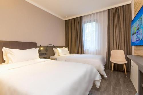 Säng eller sängar i ett rum på Hanting Hotel Beijing Fuxingmen Children's Hospital