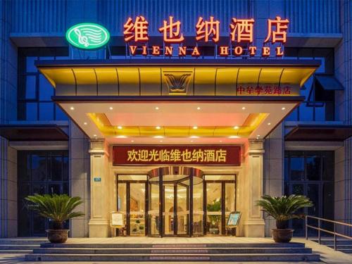 un bâtiment avec un panneau de néon devant lui dans l'établissement Vienna Hotel Zhengzhou Only Henan Movie Town, à Zhongmou
