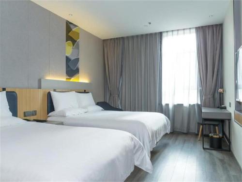 سرير أو أسرّة في غرفة في Hanting Hotel Changchun People's Square Chongqing Road
