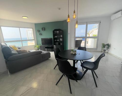 een woonkamer met een tafel en stoelen en een bank bij Ático Alegría Del Mar in Torrox Costa