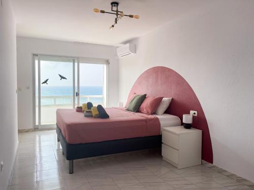 een slaapkamer met een groot bed met een roze hoofdeinde bij Ático Alegría Del Mar in Torrox Costa
